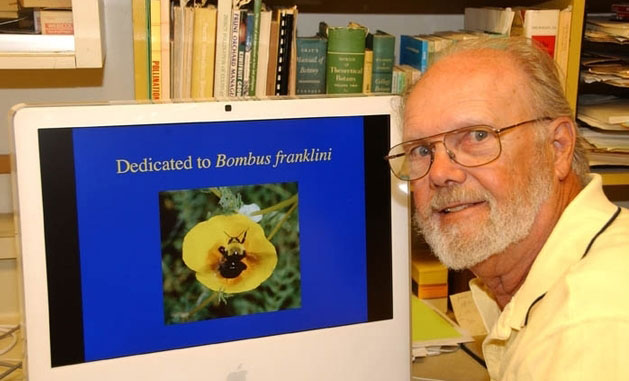 Robbin Thorp poses next to computer screen showing a Franklin’s bumblebee.