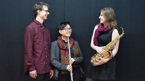 Ensemble of musicians on stage wearing maroon and black