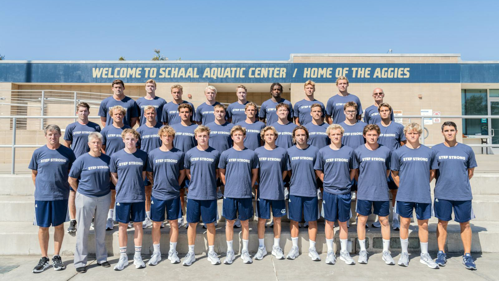 Water polo players pose for photo wearing shirts that read "Stef Strong"