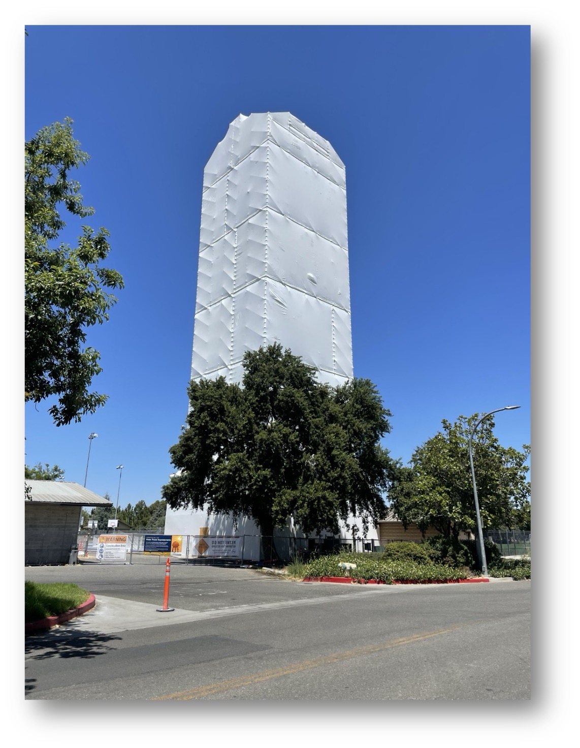 Touchdown Tower during the restoration process. The wrap around the scaffolding protects project workers from the elements and also serves to contain dust and debris from the sandblasting and repainting process.  