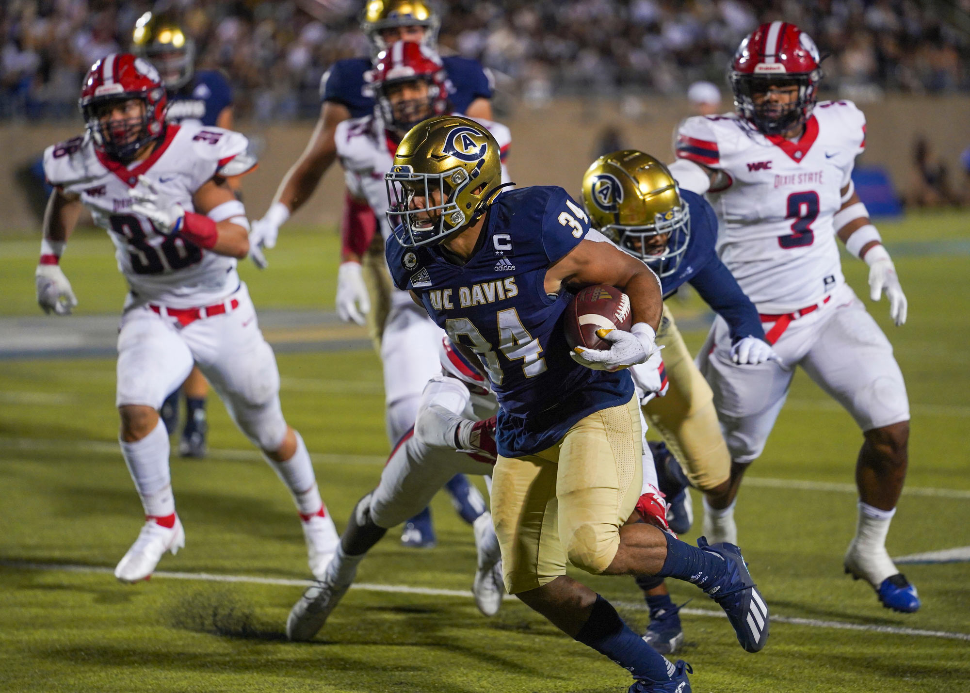 Aggie football player runs the ball.