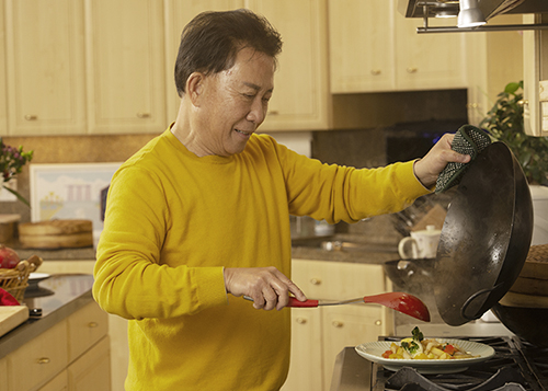 Martin Yan plates stir fry from wok