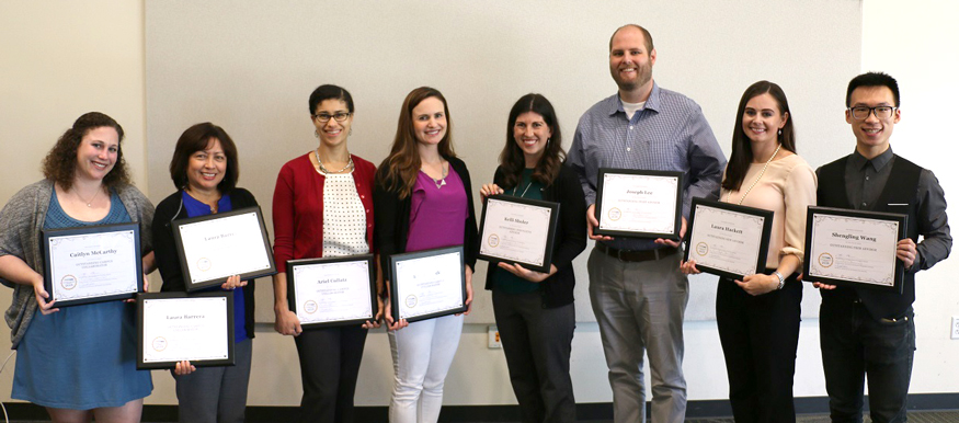 Advising award recipients, holding plaques.