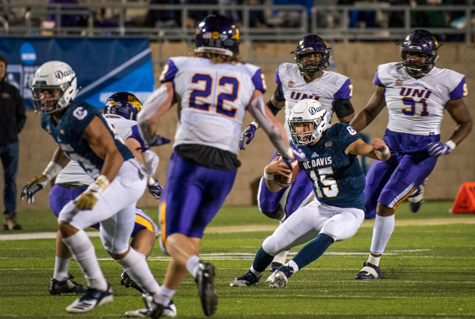 Aggie quarterback maneuvers through three defenders.