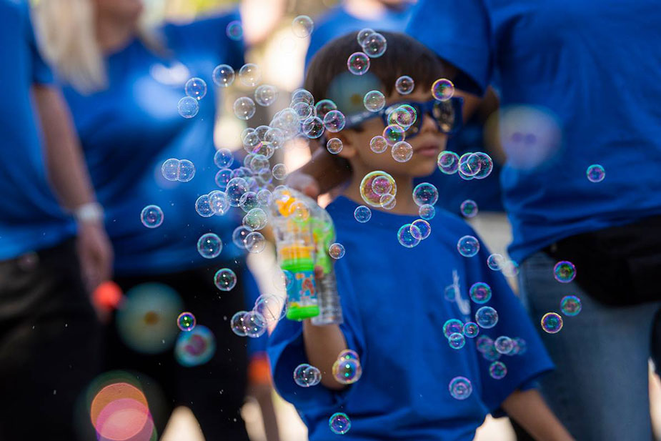 Boy blows bubbles in parade,