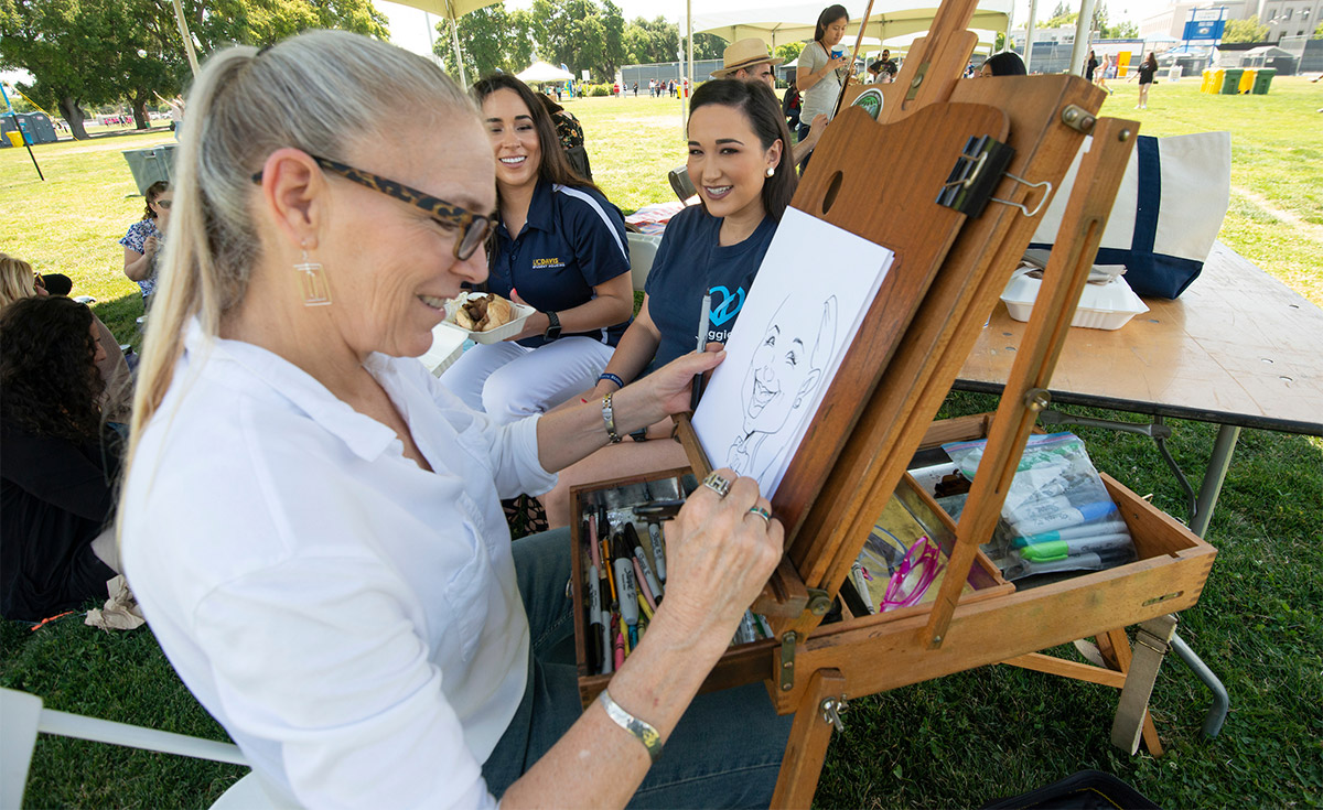 An illustrator draws a caricature of a staff member.