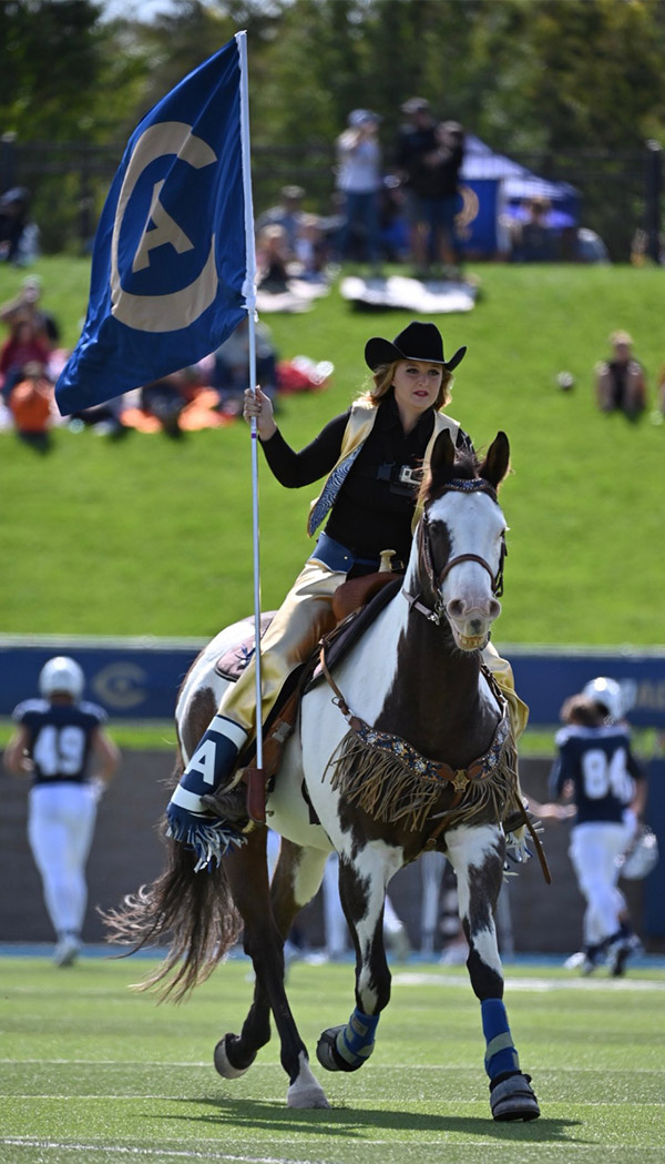 Tatum Burris rides Maverick onto the football field.