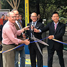 Four people cut a ribbon.