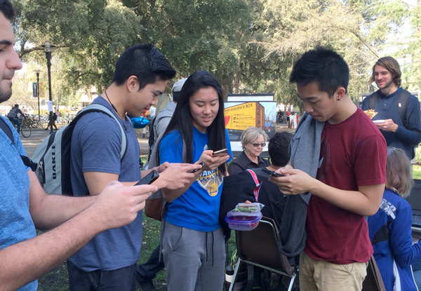Students on mobile devices, on the Quad