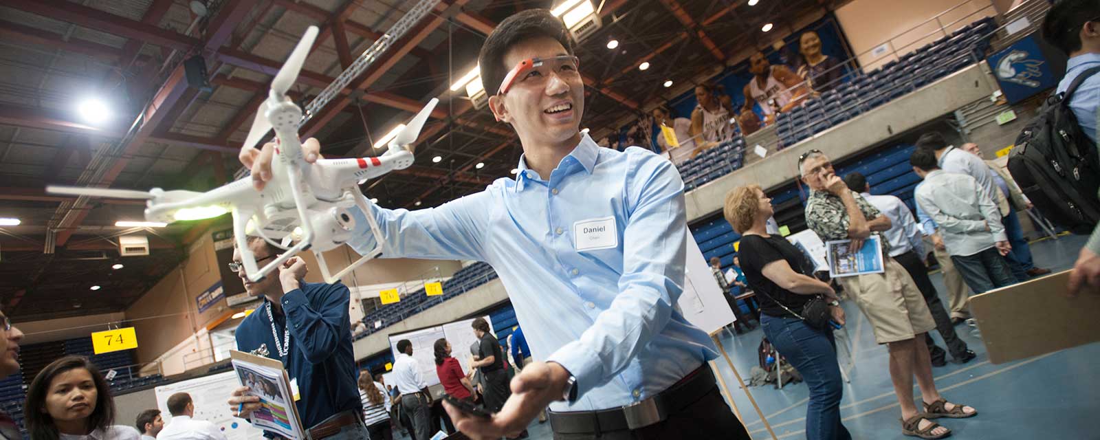 male student holding a drone