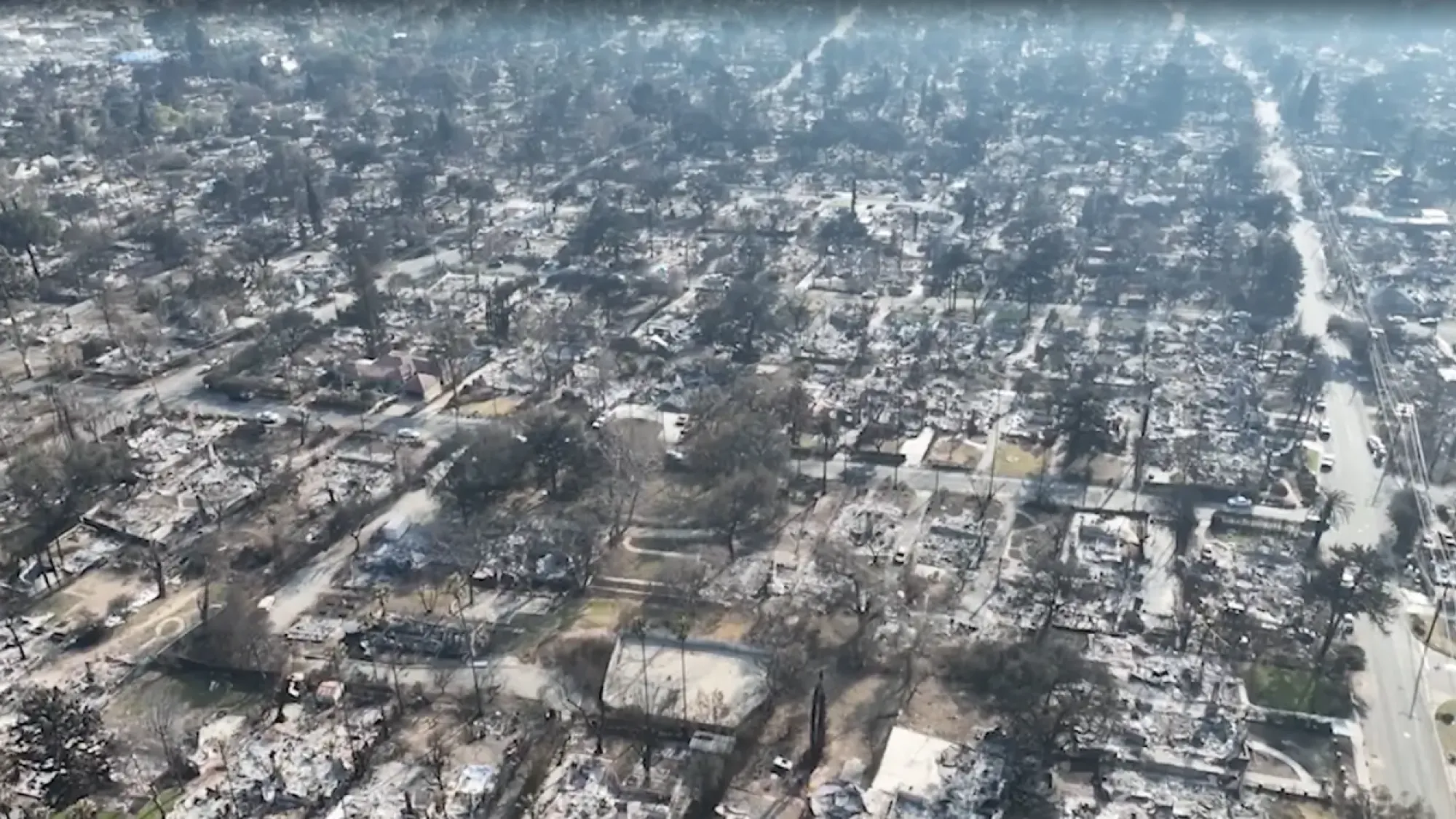 Aerial photo of charred, ash-covered neighborhood after devastating wildfire