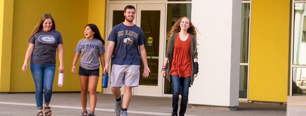 four students walking out of the residence halls