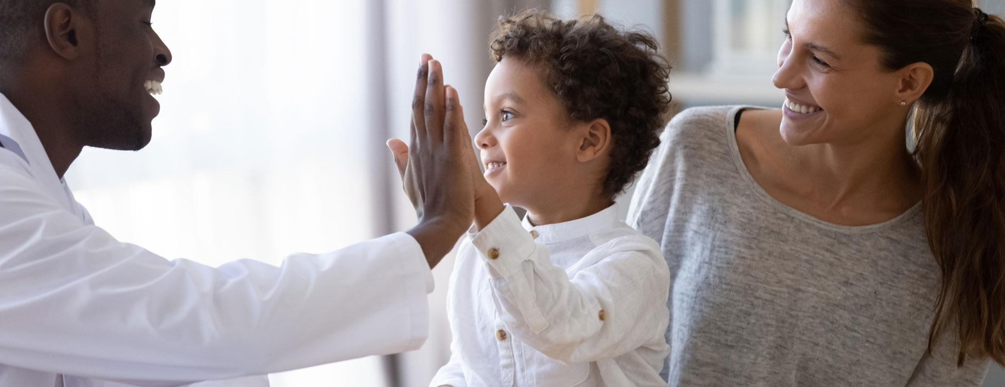 A doctor high fives a child patient