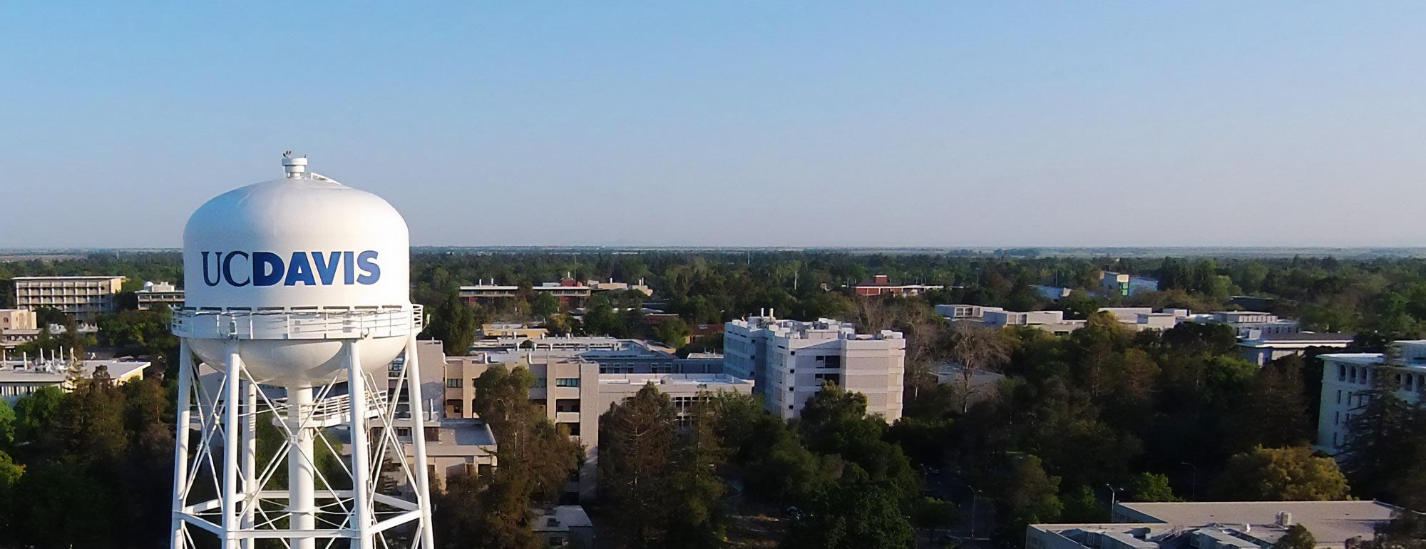 Aerial view of UC Davis water tower and campus buildings under clear blue sky