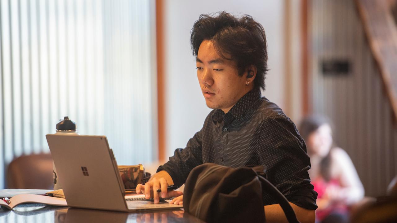 A student sits on his laptop at the Silo at UC Davis. 