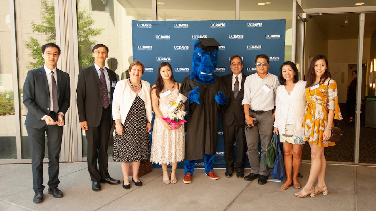 Gunrock stands with students during the 2018 International Student Graduation Celebration.