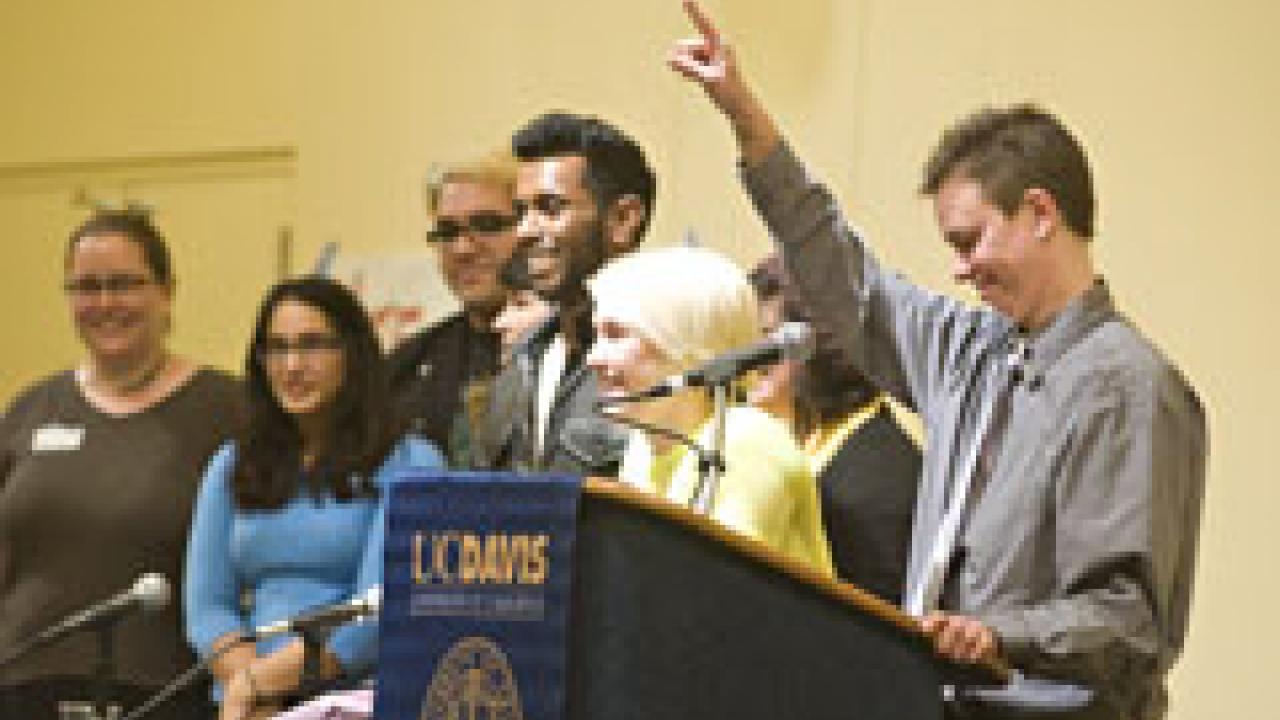 Sheri Atkinson, right, standing beside the staff of the Lesbian, Gay, Bisexual and Transgender Resource Center, tells the town hall audience in the ARC Ballroom the night of March 1: 'I'm really excited to see this place full: Don't mess with th