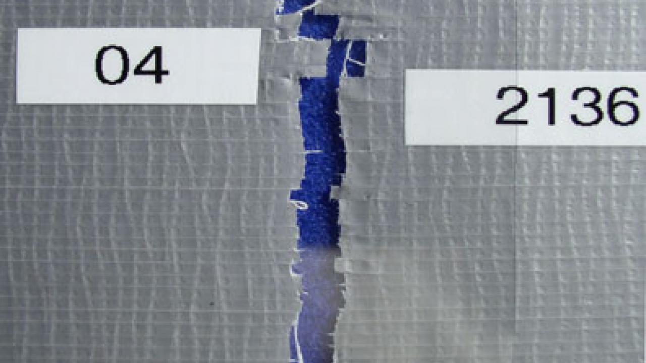 The open seam between two pieces of duct tape, the pieces having formerly been attached, to show how the pieces might be reliably matched.