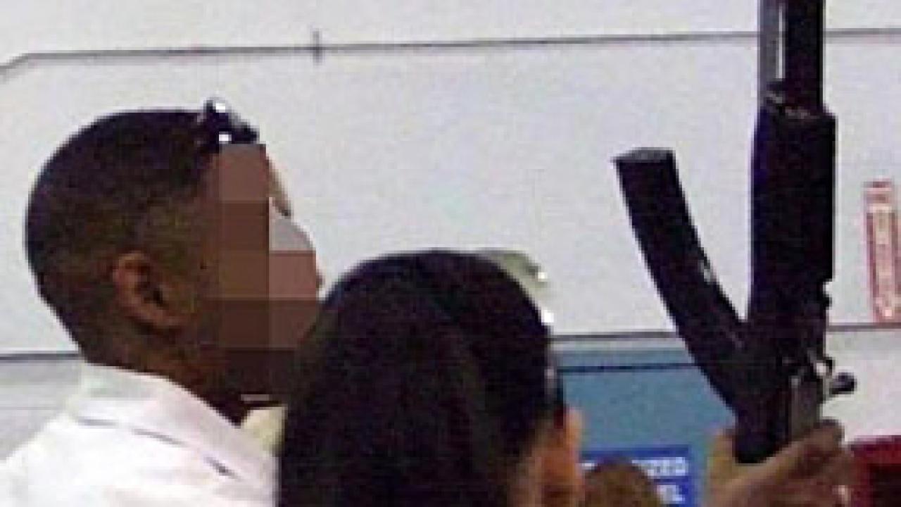 Photo shows a woman allegedly making a straw purchase of an SKS rifle with a high-capacity magazine and a bayonet.