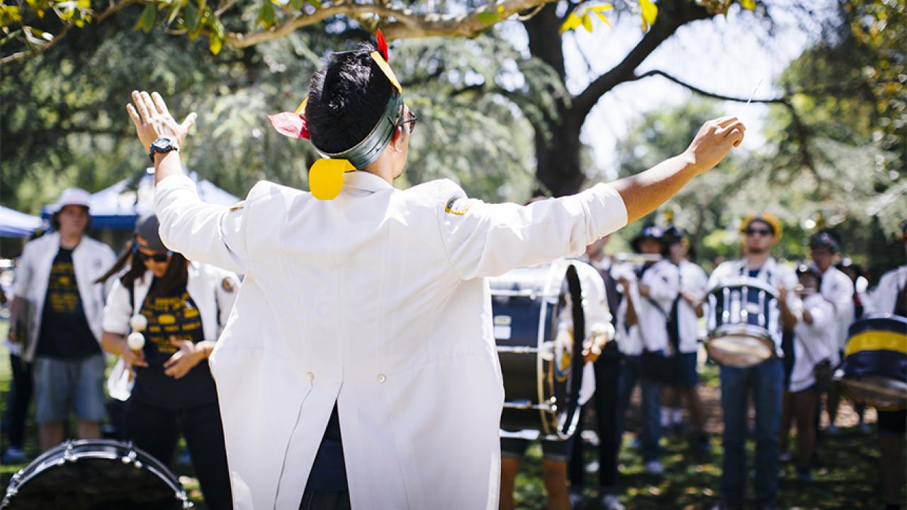 A student leads the Cal Aggie Marching Band-uh!