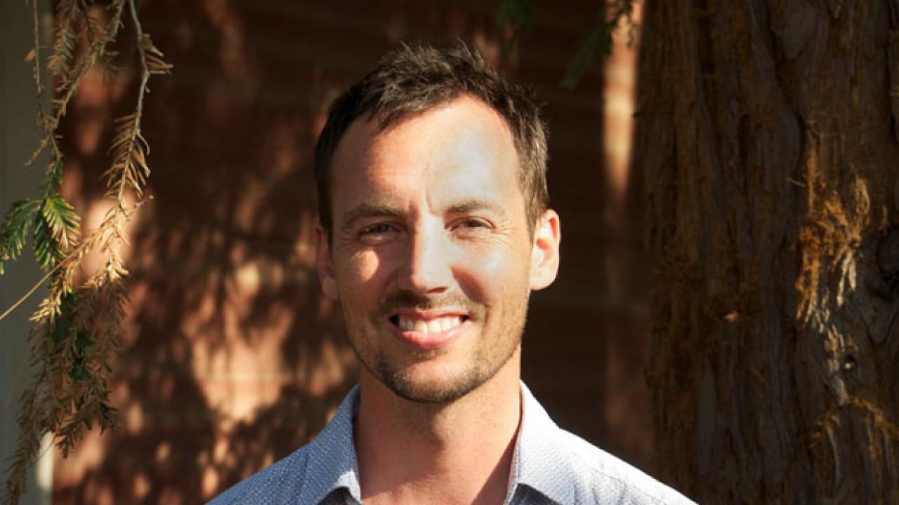 Photo: Professor Benjamin Houlton against backdrop of the bark of a redwood tree