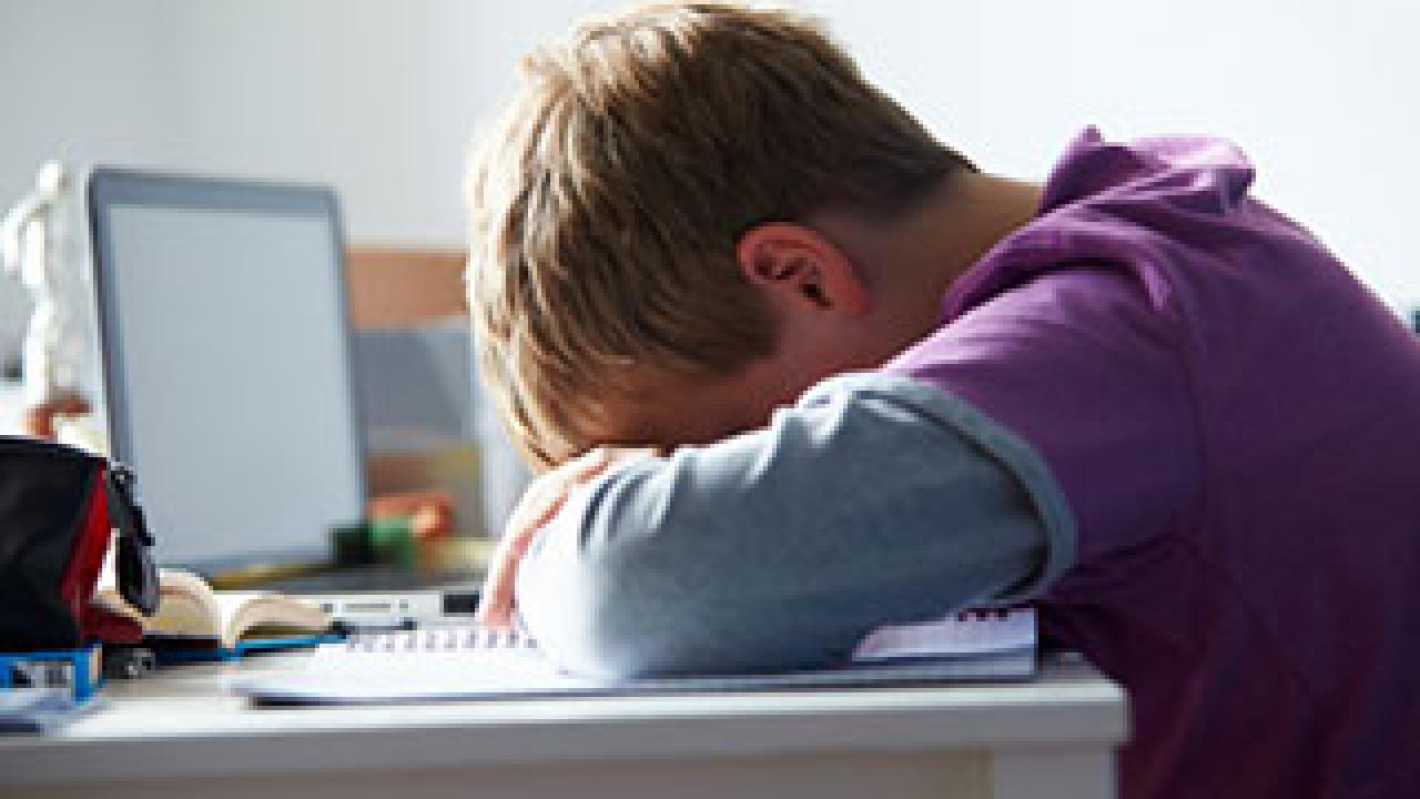 Boy with head on desk