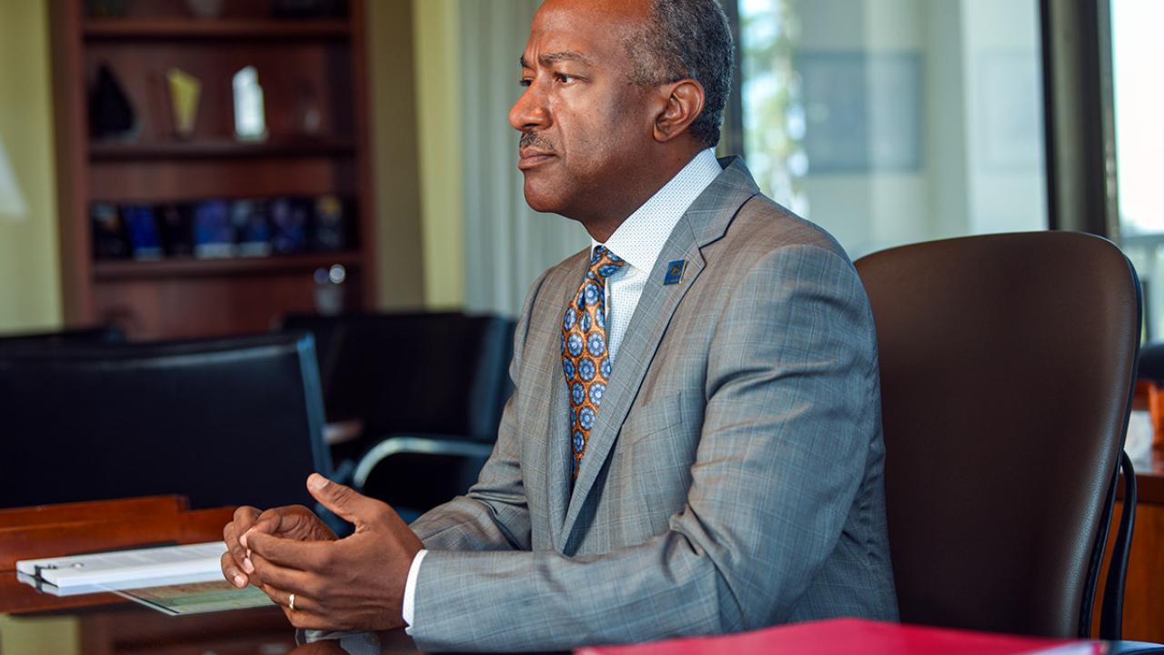 Chancellor Gary S. May sitting at a desk.