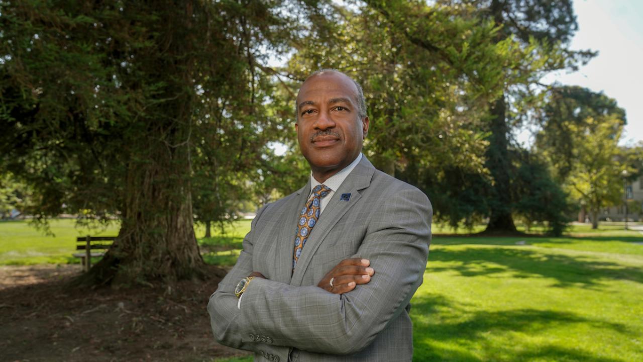 Photo of the chancellor on the quad with his arms crossed.