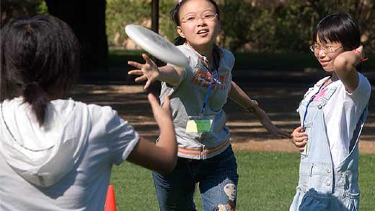 Three Chinese girls playing Frisbee