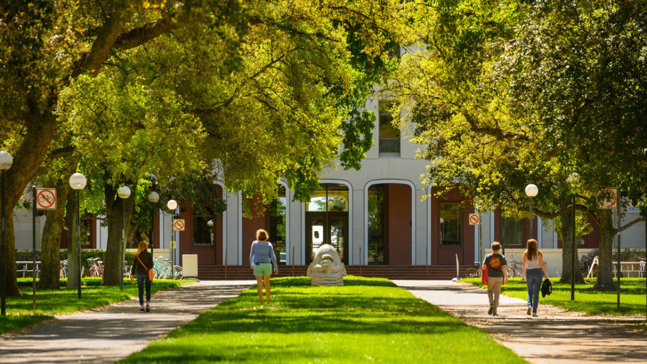 students walking on campus in front of Mrak Hall - latest coronavirus information from Undergraduate Admissions