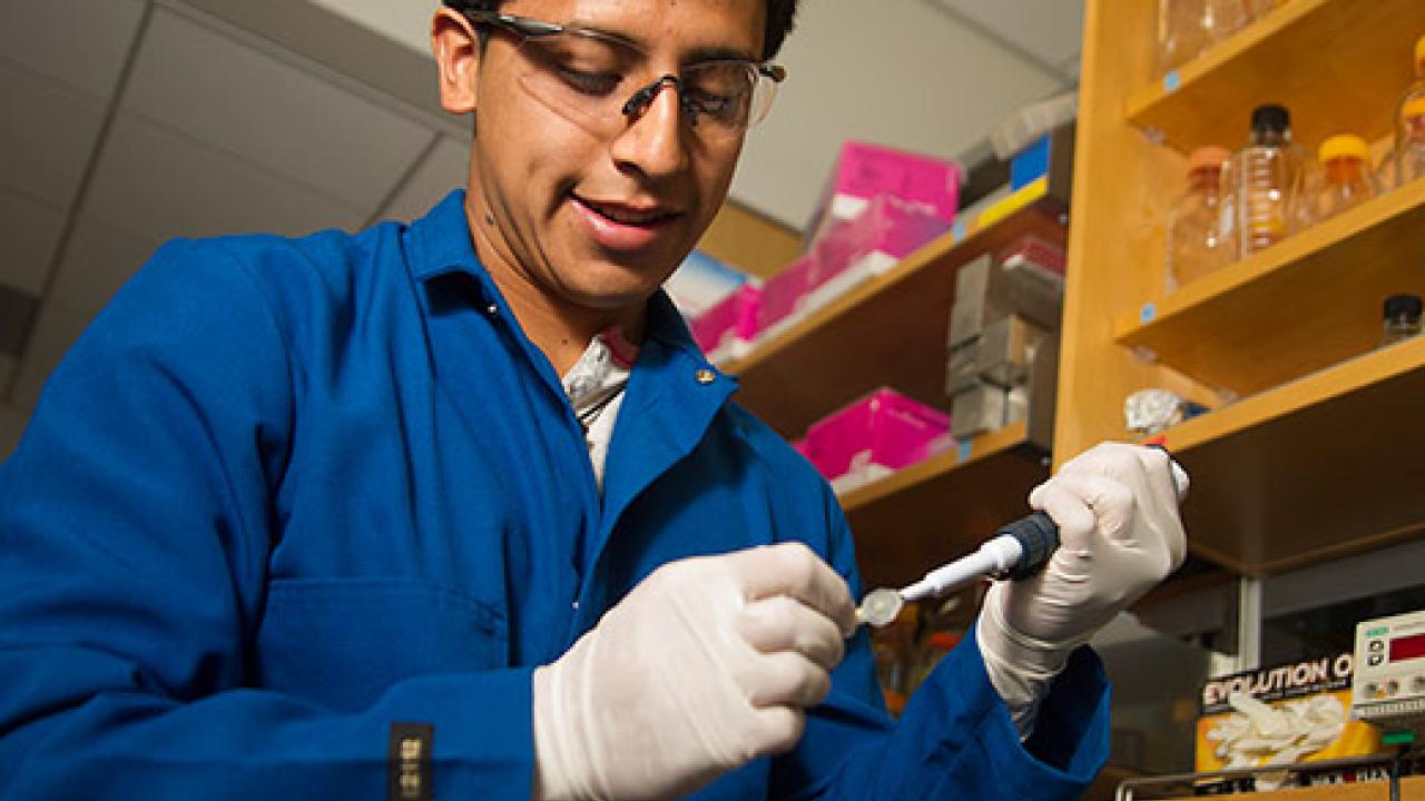 Man in lab coat, goggles and gloves in a chemistry lab.