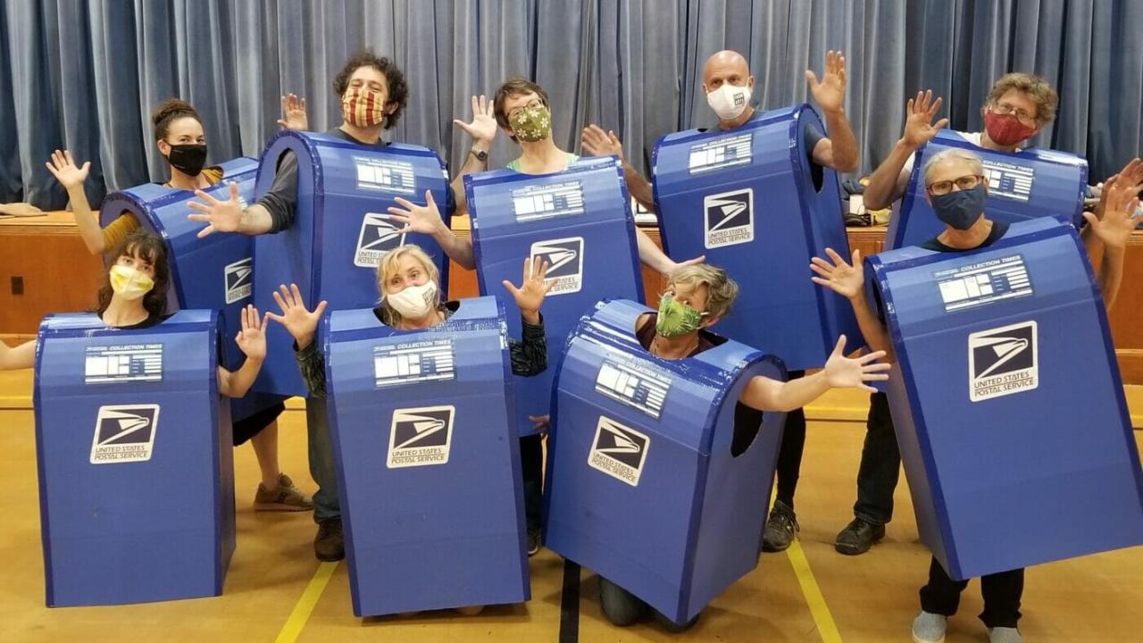 Group of people wearing mailbox costumes.