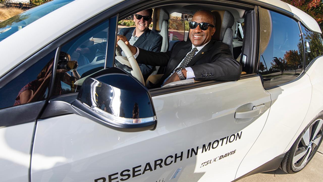 UC Davis Chancellor Gary S. May and BMW's Monterey Gardiner behind the wheel of an electric i3