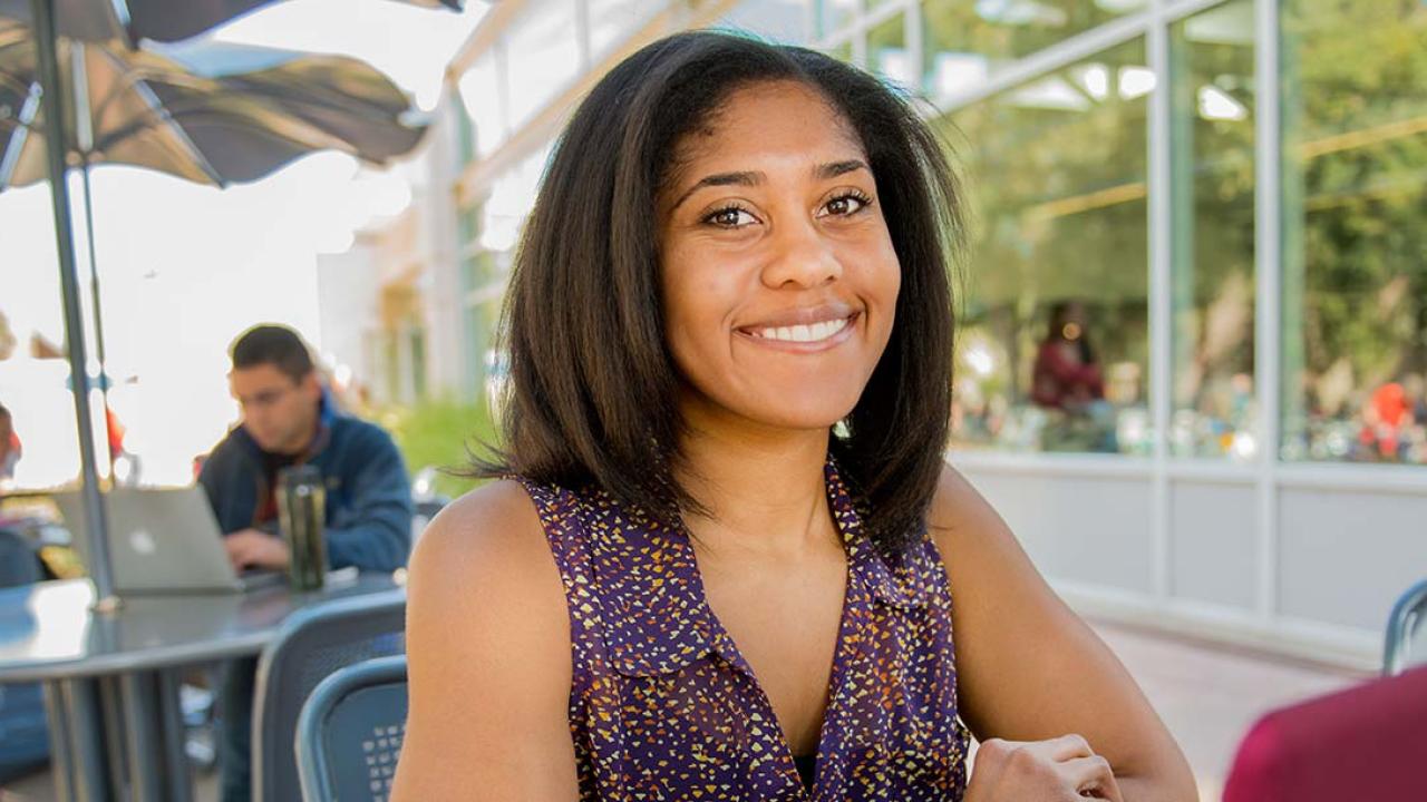 Woman sitting at a table smiling at the camera