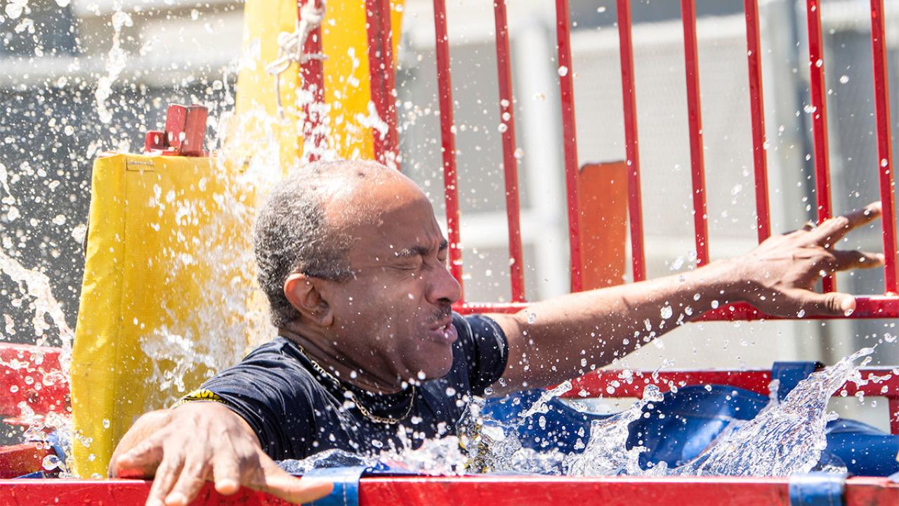 Chancellor Gary S. May falls into a dunk tank.