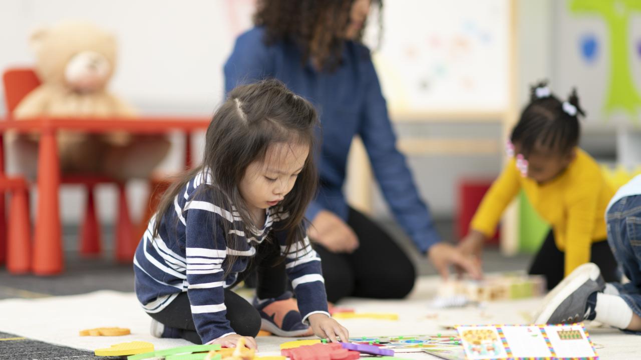 Toddlers doing puzzles on the floor