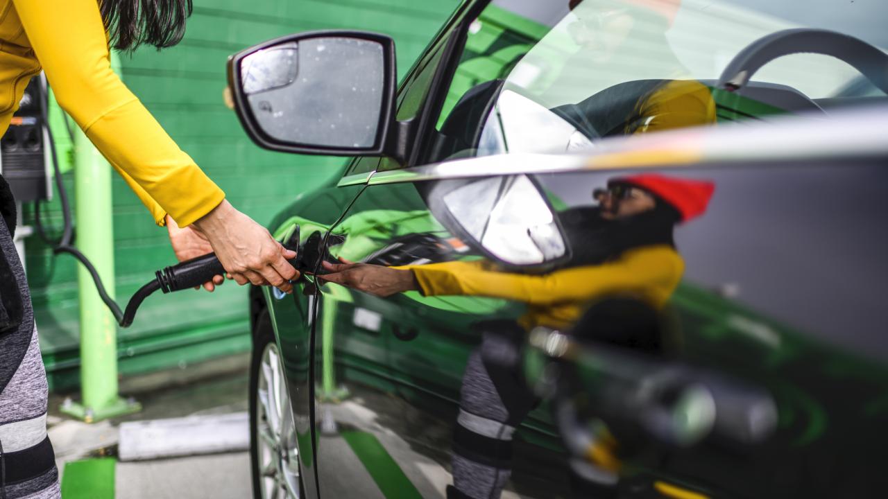 Woman charges electric vehicle 