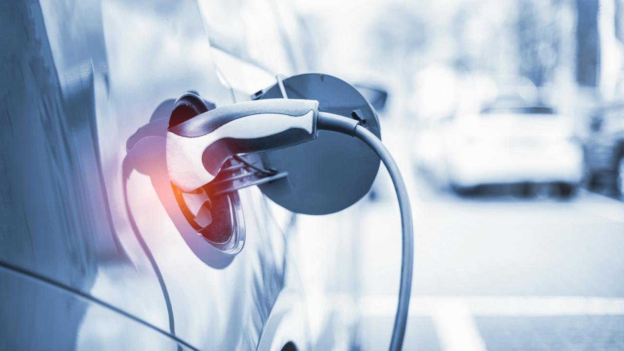 closeup of charger inserted into gray electric vehicle
