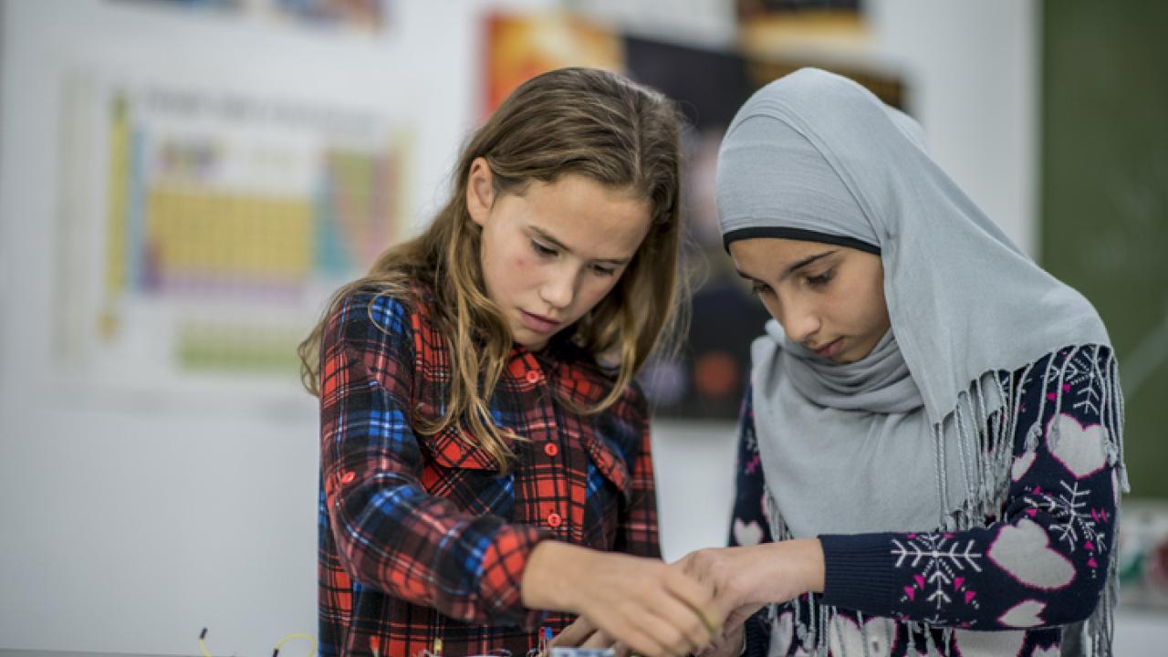 Girls working on science kit. 