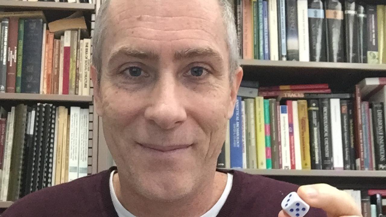 Anthropology professor Jelmer Eerkens holding a modern die.