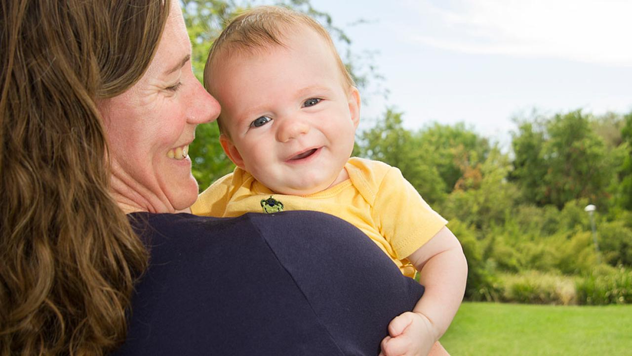 Mother holding baby who faces the camera