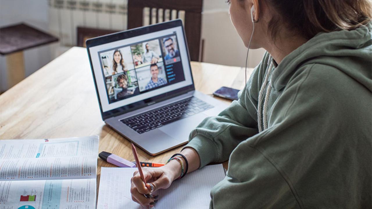 A student looks at a screen showing an instructor and classmates