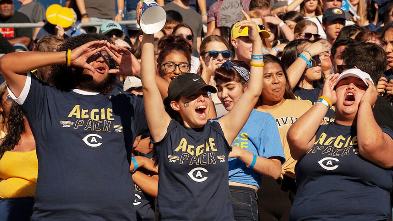 Members of the Aggie Pack cheer at Homecoming 2018.