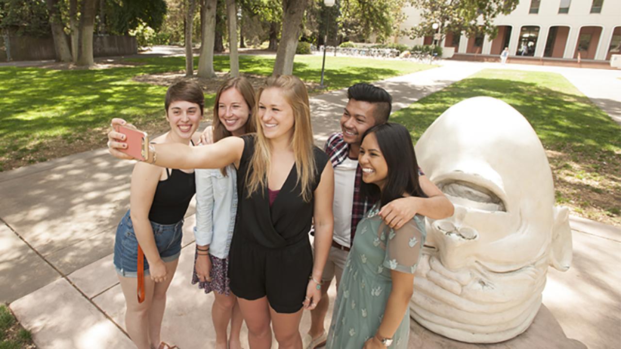 Five students  take a selfie with one of the iconic Eggheads at UC Davis