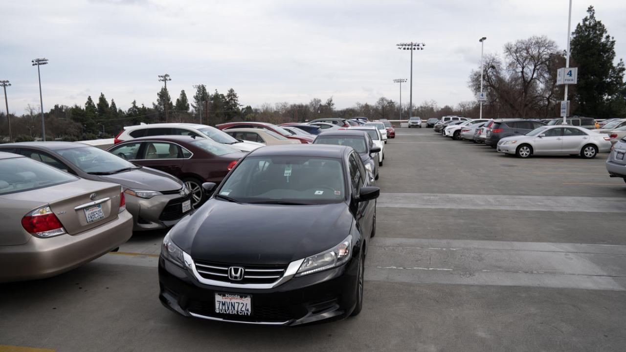 Cars parked in aisle of parking structure.