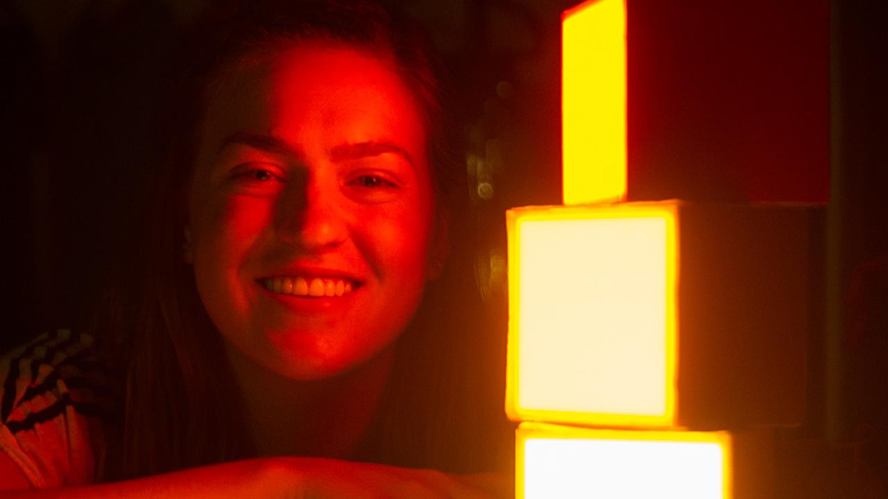 Sydney Patterson with her child-friendly lighting design photographed in a red light 