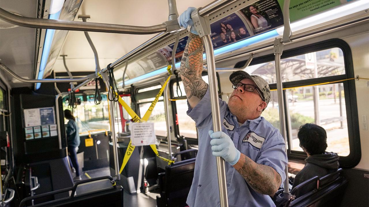 A worker disinfects a Unitrans bus.