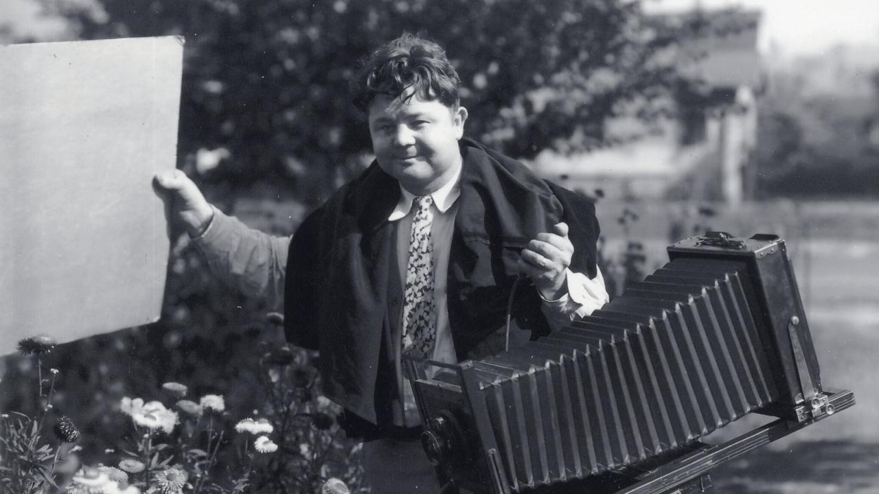 Black and white photo of Paul W. Hollingshead in 1931 carrying his photography equipment.