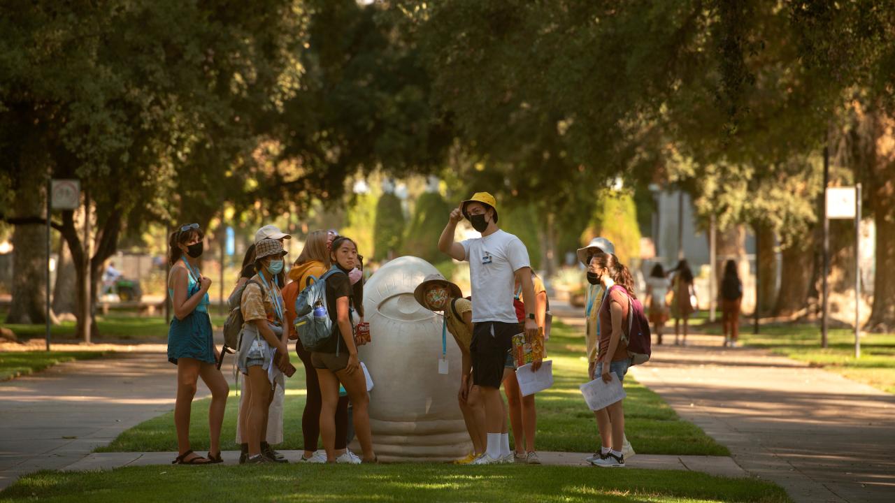 Orientation student leaders do a practice tour of campus, stopping with the Egg Head outside Mrak Hall, before Orientation Day