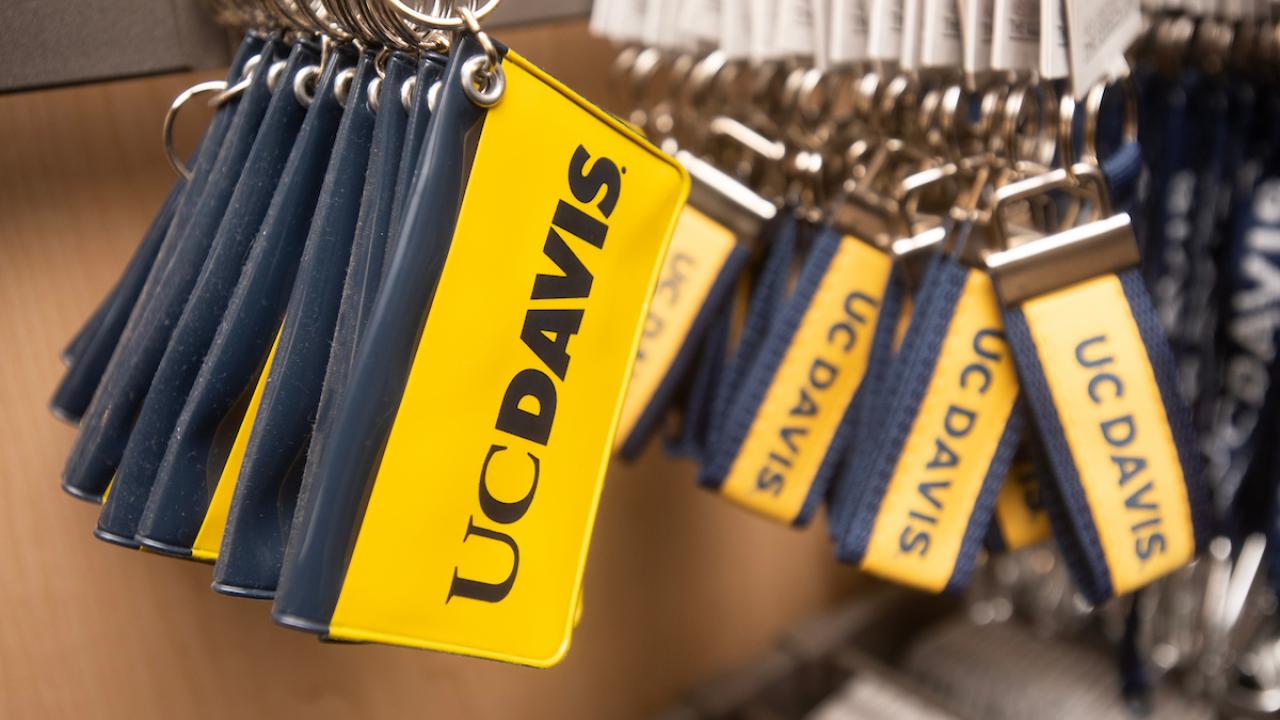 Yellow key tags with UC Davis logo and navy blue fobs on a metal rack